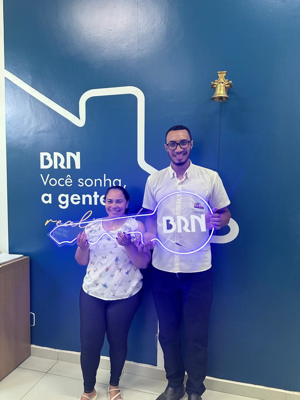 Casal sorrindo segurando a chave do apartamento novo